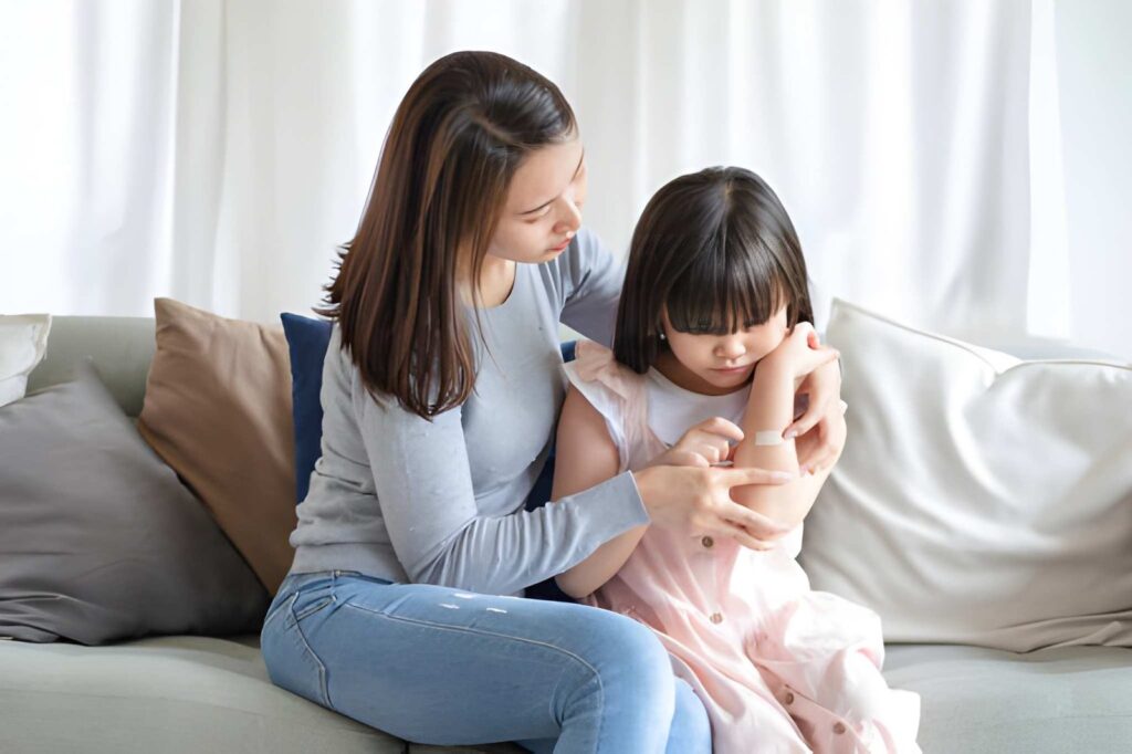 a mom holding her daughter who has wound on the arm